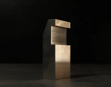 Compact tungsten bucking bar with a notched step cut, standing upright on a dark workbench