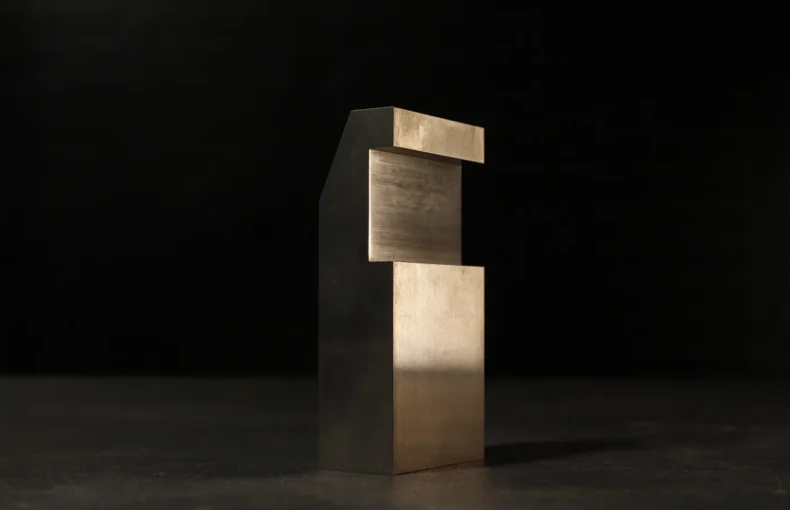 Compact tungsten bucking bar with a notched step cut, standing upright on a dark workbench