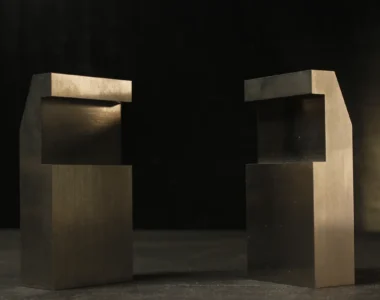 Two tungsten bucking bars with mirrored notched, stepped profiles facing each other, showing the offset geometry that clears an edge or flange