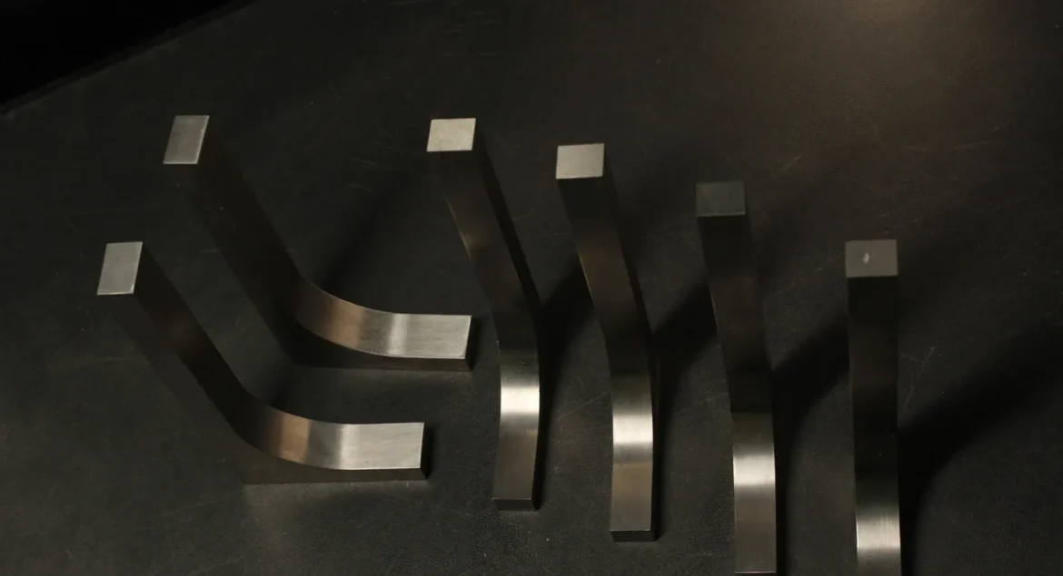 Six tungsten bucking bars of graduated sizes and curved profiles fanned out on a dark bench, showing the range a downsized tungsten set covers
